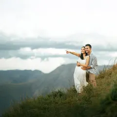 Looking out towards the future together from a mountain crest. This shot captures a sense of shared dreams and adventure, set against a beautiful, expansive backdrop.