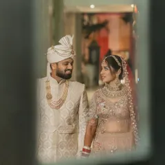 A stolen moment, captured through a reflection. The couple shares a look of love and admiration, a quiet conversation that no one else is a part of. These creative frames add a layer of artistry to your story.