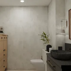 A wider view of the powder room, showcasing the balance between the dark stone basin, the light wood chest of drawers, and the textured concrete-finish walls.