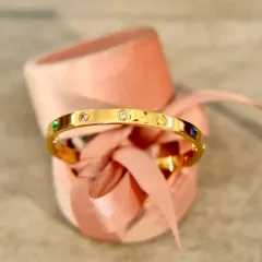 A timeless gift of love. This elegant gold-tone bangle with multi-colored stones is a beautiful and classic piece that can be cherished for years to come.