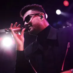 A close-up portrait of the singer, where the stage lights create a soft glow. This intimate perspective brings you closer to the artist's experience on stage.