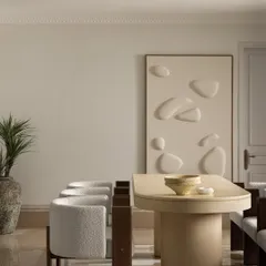 A wider view of the Ecru Maison dining room, showing the pedestal dining table and the textured wall relief that adds an artistic layer. The space feels minimal, layered, and sophisticated.