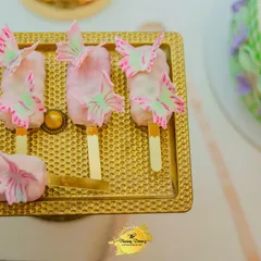 These butterfly-themed cakesicles are a perfect example of how I coordinate sweet treats with the event's decor. Placed on an elegant gold tray, they become part of the visual story.