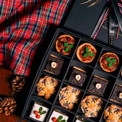 Our Christmas taster box offers a delightful variety of festive sweets. It includes traditional mince pies, rich chocolate hazelnut bites, and iced fruitcake squares, all beautifully arranged for gifting.