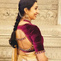 Our client Krupa radiates poise in this custom-designed creation. We chose a deep maroon velvet to contrast with her saree, adding elegant bead detailing along the unique back cutout and sleeves for a touch of refined drama.