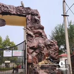 A close-up of the right pillar of the Rohtak Zoo gate, showing a dynamic scene with a leopard chasing antelope, all sculpted with realistic detail.