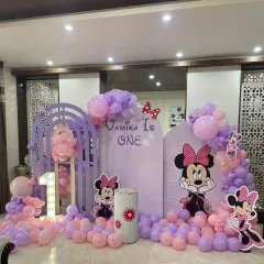 For Vamika's first birthday, we created this beautiful Minnie Mouse wonderland. The setup includes a custom arched backdrop, a full balloon garland in shades of purple and pink, and a light-up marquee number '1' to mark the special milestone.