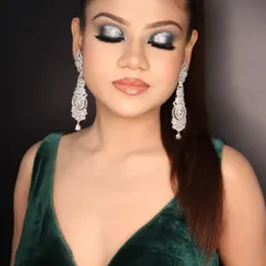 Eyes closed to showcase the beautiful glitter and blending of the green and silver smokey eye makeup.