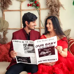 Let's announce it with a headline. We use creative props like this custom "The Baby Post" newspaper to add a fun and personal touch to your couple's maternity session, making your announcement truly unique.