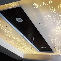 A beautiful false ceiling design where a floral pattern is cut into a Corian panel and backlit. This creates a soft, diffused light and an enchanting, decorative effect.