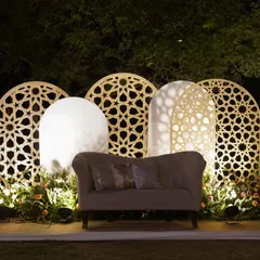 We love playing with patterns and light. This photo booth features a backdrop of backlit jali panels in asymmetric arched shapes, creating a beautiful and intricate setting for pictures.