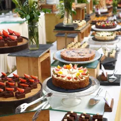 A beautiful dessert table from a Holi party, featuring a variety of cakes, tarts, and bite-sized sweets. We can create a full dessert spread to match the theme and scale of your celebration.