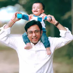 The pure joy of being lifted up by dad. This candid shot from an outdoor family photoshoot captures a perfect, unscripted moment of father-son happiness.