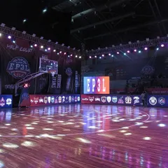 An empty court view of the EP3L setup, showcasing the polished wooden floor and the surrounding digital banners displaying team logos. This highlights the clean, professional look of our arena before the action begins.