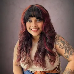 The combination of the shag cut, the bangs, and the red highlights creates a truly unique and head-turning style.