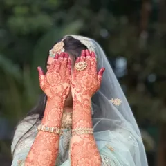 A beautiful shot of a bride showing off her mature henna stain. The floral design has developed into a rich reddish-brown color, a testament to the quality of natural henna.