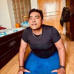 Practicing Bhujangasana, or Cobra Pose, at home. This backbend is fantastic for strengthening the spine and opening the chest. I always emphasize rolling the shoulders back to create space and avoid pinching the lower back.