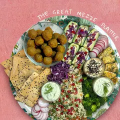 This is my Great Mezze Platter, a perfect party starter. It's loaded with green falafels, a fresh tabbouleh salad, cucumber hummus sticks, lavash crackers, and multiple dips. It brings a taste of the Mediterranean to your event.