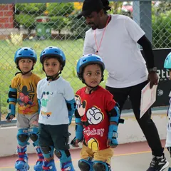 A coach providing guidance to some of our youngest skaters. We give individual attention to ensure every child understands the basics of posture and balance before they start moving.