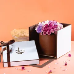 Introducing "Bloom," our signature mini cakes redefined with elegant fresh floral arrangements. This chocolate mini cake is topped with a beautiful bouquet of purple and white flowers, making it a stunning gift.
