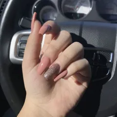 A beautiful set of long, coffin-shaped nails in a dusty rose color, with a single accent nail in a complementary rose gold glitter.