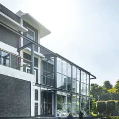 Another angle of the architectural intervention at the Media Monks campus, highlighting the contrast between the original dark brick building and the modern, light-filled glass extension we designed.