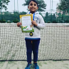 Manit Shokeen proudly displaying his bronze medals for both the U-10 and U-8 categories. His dedication on the court led to this fantastic achievement in the Tennisoholic tournament.