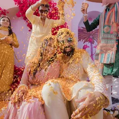 A Haldi ceremony bursting with life and color. This moment of pure, uninhibited fun, with the couple showered in marigold petals by their loved ones, is what makes Indian weddings so special.