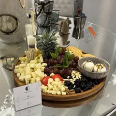 A charcuterie platter curated for the luxury decor brand Maison Sia. This spread includes artisanal cheeses, fresh pineapple, grapes, nuts, and creamy mozzarella balls, all arranged to be as beautiful as the art surrounding it.