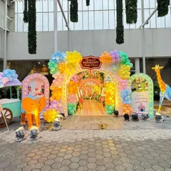 The grand entrance to the carnival party, with a multi-layered balloon arch and a tunnel leading guests into the main event area.