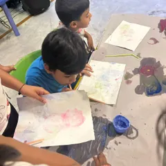 Two young children deeply focused on a bubble painting activity. This sensory art technique is always a huge hit, creating beautiful patterns with minimal mess.