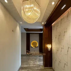 A beautiful play of light and texture in this hallway. A sculptural chandelier serves as a centerpiece, while a backlit art niche and fluted wall panels add layers of visual interest.