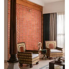 An exposed terracotta brick wall adds texture and warmth, creating a soulful backdrop for the family's ornate antique chairs. Every element here has a reason and carries a story.