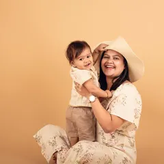 A playful moment between mother and child in the studio. Using simple props like a hat can add a fun element to your family portraits.