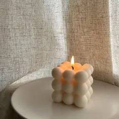 Setting a cozy mood with a lit bubble candle. Its unique shape and soft light are perfect for relaxing with a good book.