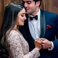 An intimate moment from a reception or engagement party. The groom's gentle kiss and the bride's serene smile are captured in a close-up, highlighting their connection.