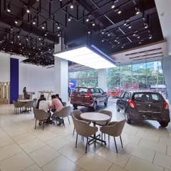 A view of the spacious and modern interior of a redesigned Maruti Suzuki Arena showroom. We focused on creating an open, welcoming environment with clear sightlines to the cars, comfortable customer seating areas, and dynamic ceiling and lighting design to enhance the retail experience.