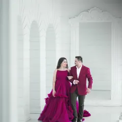 A candid moment of the couple walking through a beautiful white arched hallway. This shot showcases a blend of classic architecture and natural interaction for a pre-wedding photoshoot.
