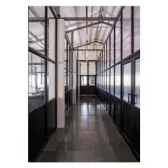 Another view of the office corridor, highlighting the polished concrete floors and the lofty exposed metal roof, which contribute to the space's clean, industrial aesthetic.