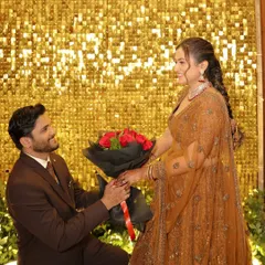 A golden shimmer wall provides a stunning and glamorous backdrop for key moments, like this romantic proposal during an engagement party. It creates a vibrant and celebratory atmosphere perfect for photos.