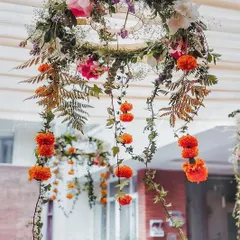 Minimalistic floral chandeliers created for a Mehndi ceremony. We used simple hoops adorned with greenery, marigolds, and other delicate flowers to add a touch of beauty to the ceiling space.