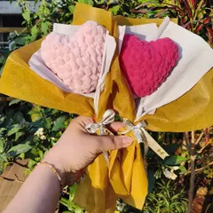 Two of our crochet sweetheart bouquets, one in light pink and one in magenta. These plush hearts are a unique way to show your love.