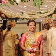 The bride's grand entrance during her South Indian wedding. Her golden Kanchipuram saree and diamond jewelry create a truly royal look.