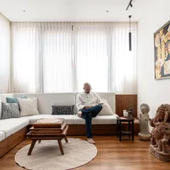 We converted what was once an outdoor balcony into this bright and cozy living area. By enclosing the space, we expanded the home's footprint and created an inviting corner that is flooded with morning light, demonstrating how smart structural changes can breathe new life into a home.