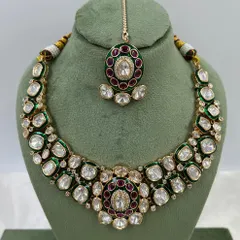 A pair of stunning oversized earrings with green and red Meenakari work, set with Moissanite stones. These are perfect as standalone statement pieces.