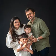A lovely family of four portrait, with the older brother proudly holding his little sister. These are the moments that truly define a family's love story.
