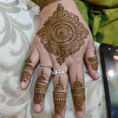 A simple and elegant mandala for a party guest. The design is focused on the back of the hand with minimal, delicate details on the fingers.