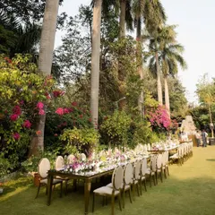This wide shot shows the scale of the outdoor dining arrangement. The table is perfectly integrated into the natural landscape, creating an immersive experience for guests.