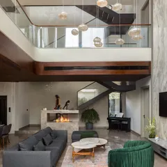 We believe in creating spaces that breathe. This double-height living room, anchored by a modern marble fireplace and cascading pendant lights, is the heart of the home. It’s a testament to our love for grand volumes, natural light, and creating a perfect balance between impressive scale and intimate comfort.