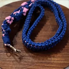 A stylish and strong macrame lanyard for your mobile phone. This one is in navy blue with pink flower details. It's 25 inches long and very durable.